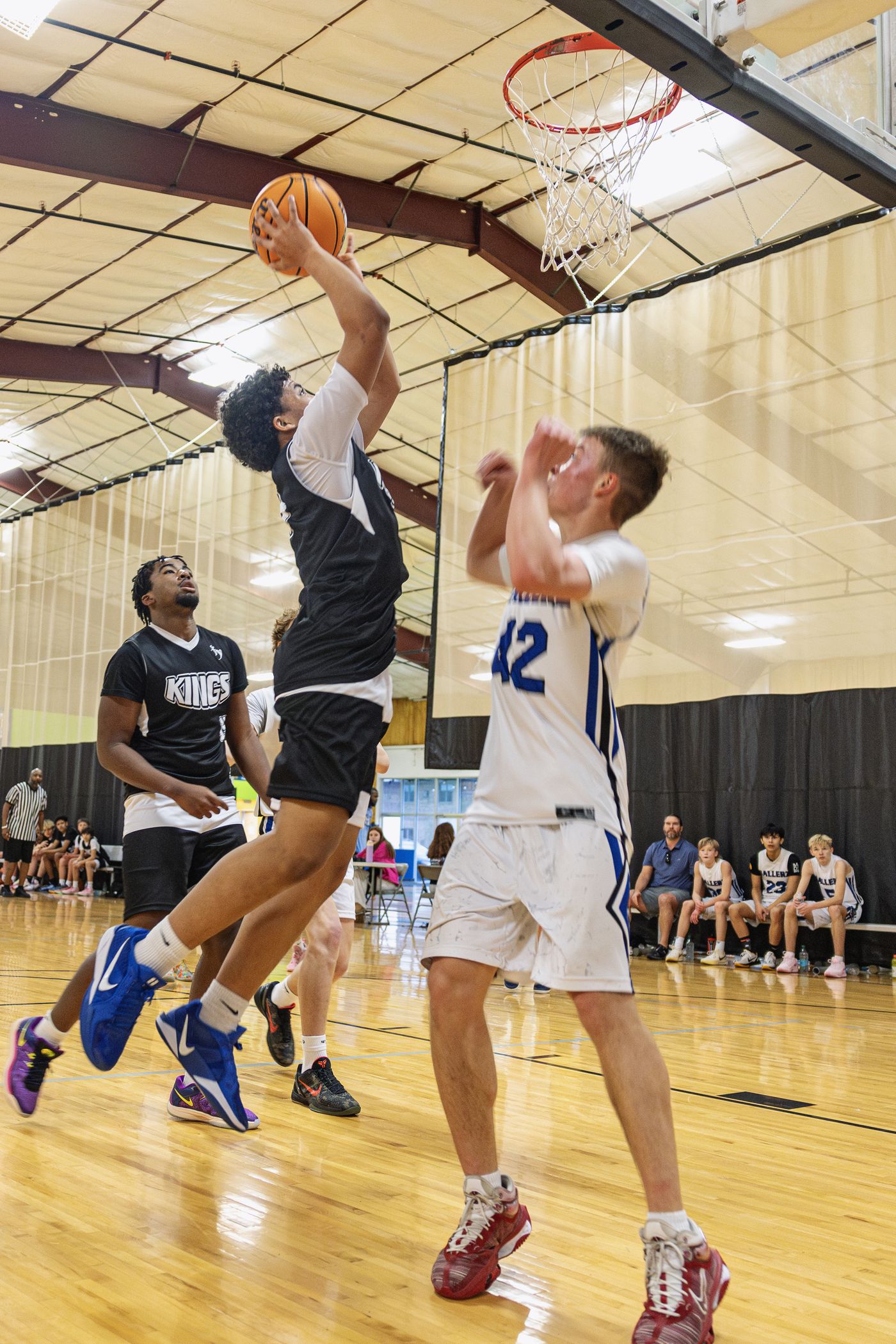 Kings player driving to the basket for a layup through defenders.