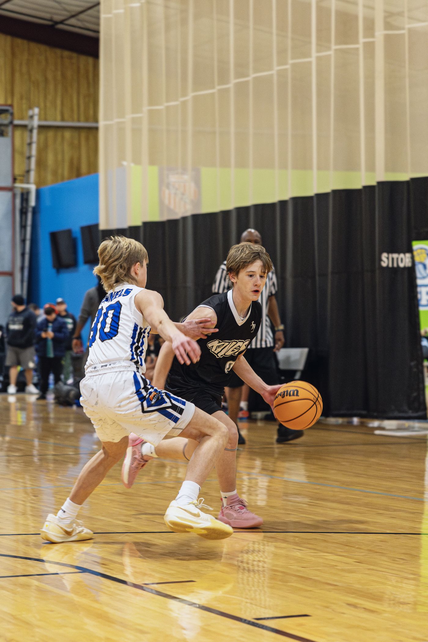 Kings player bringing the ball up the court against defensive pressure.